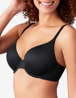 Woman wearing a black bra against a plain background